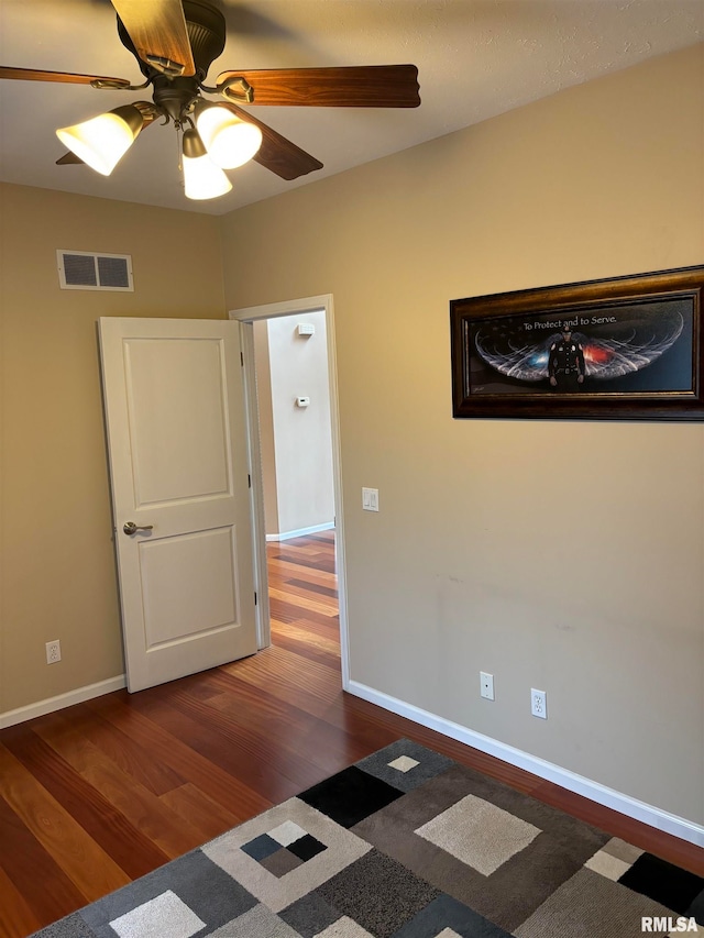 unfurnished room featuring ceiling fan and dark hardwood / wood-style floors