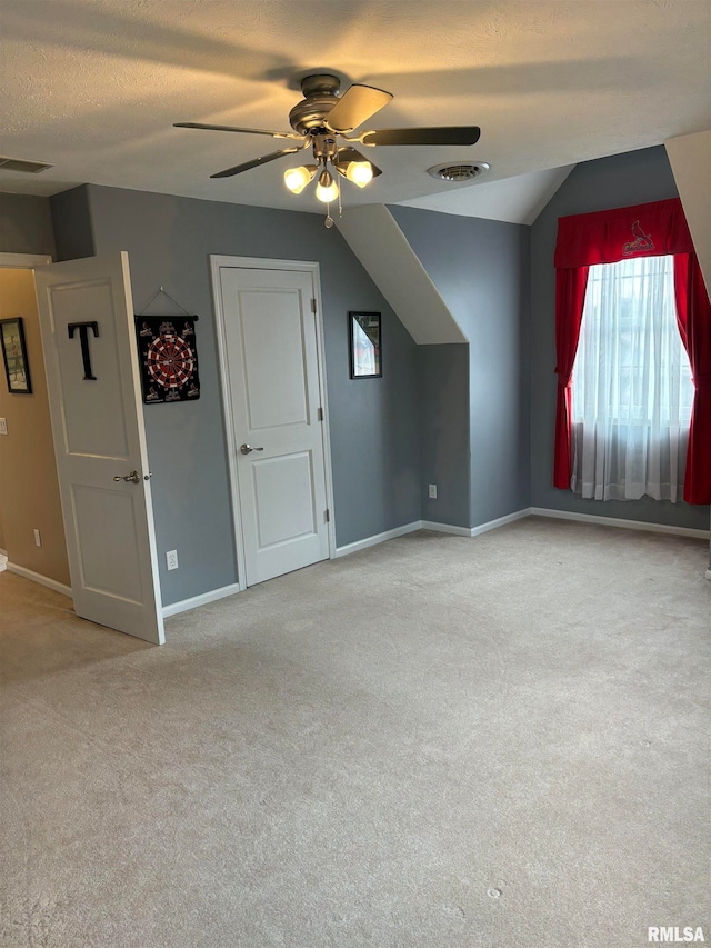 additional living space with ceiling fan, lofted ceiling, and light colored carpet