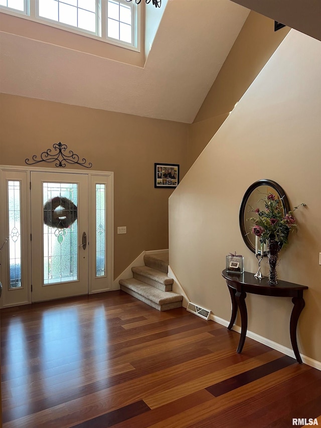 foyer featuring high vaulted ceiling, plenty of natural light, and hardwood / wood-style flooring