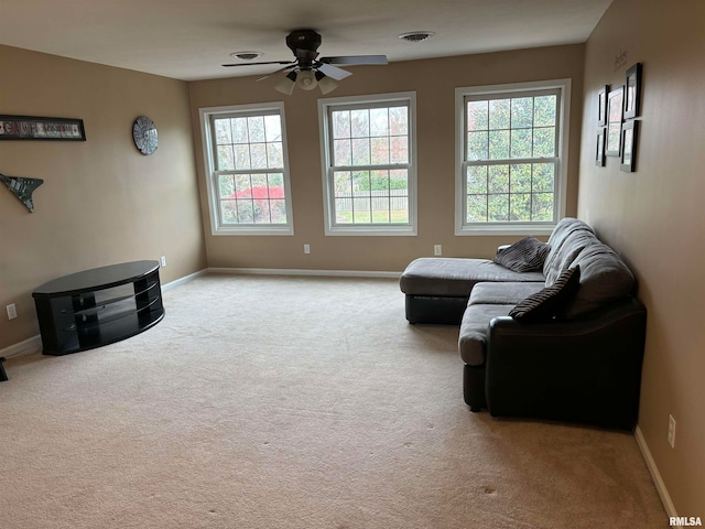 sitting room with ceiling fan, a healthy amount of sunlight, and light carpet