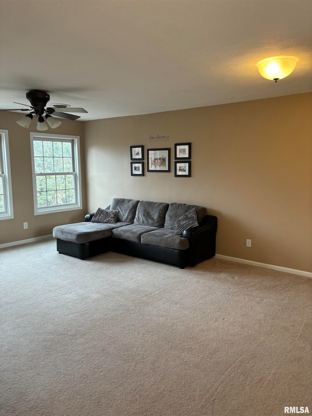 carpeted living room featuring a textured ceiling and ceiling fan