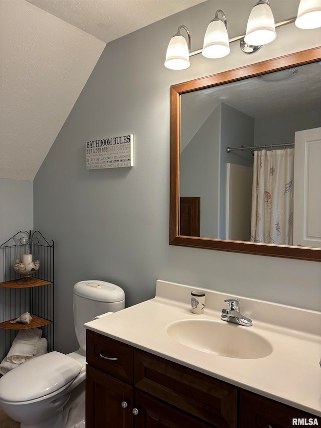 bathroom with walk in shower, vanity, vaulted ceiling, and toilet