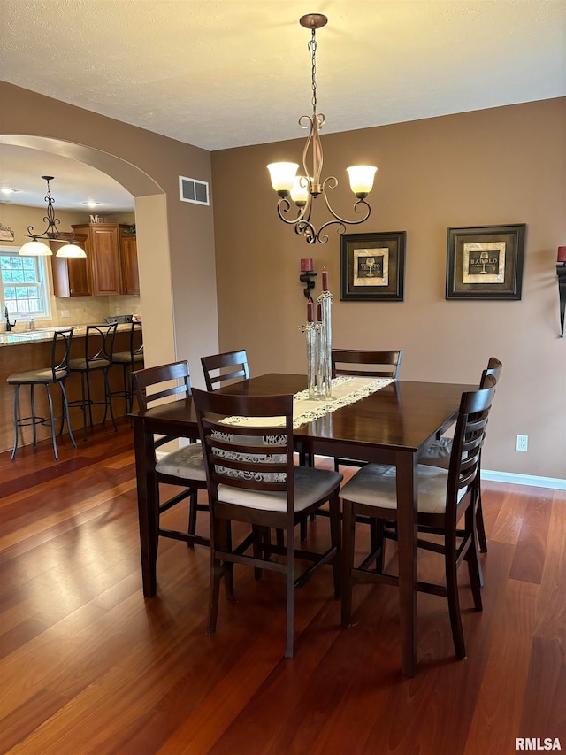 dining space featuring a notable chandelier and dark hardwood / wood-style floors