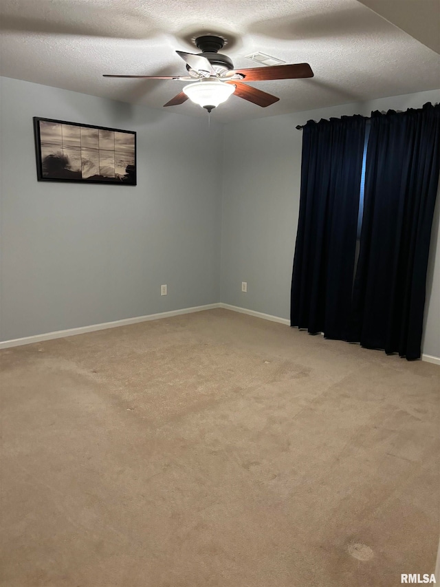 carpeted empty room with a textured ceiling and ceiling fan