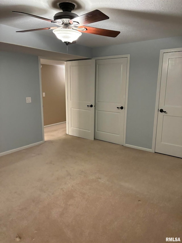 unfurnished bedroom with a textured ceiling, light carpet, and ceiling fan