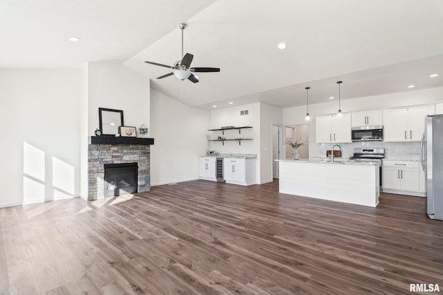 unfurnished living room featuring a fireplace, dark hardwood / wood-style flooring, vaulted ceiling, and sink