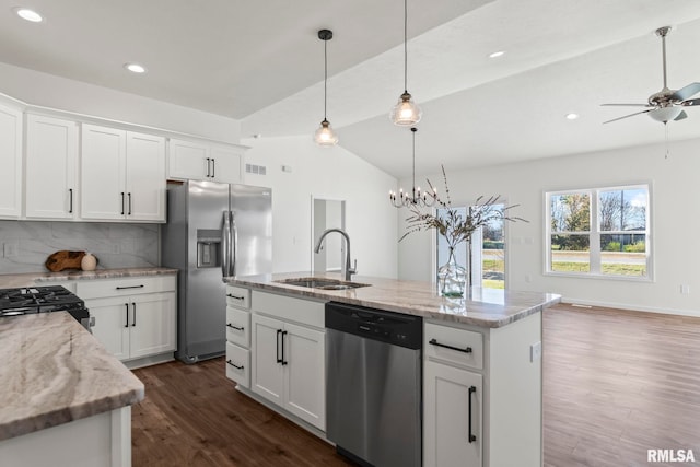 kitchen with white cabinets, vaulted ceiling, sink, and stainless steel appliances