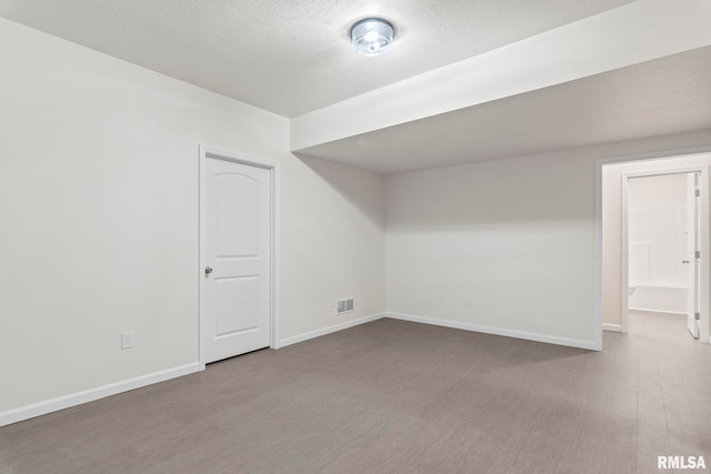 bonus room featuring wood-type flooring and a textured ceiling