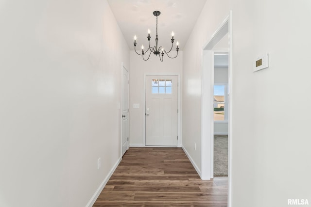 doorway to outside with dark hardwood / wood-style flooring and a notable chandelier