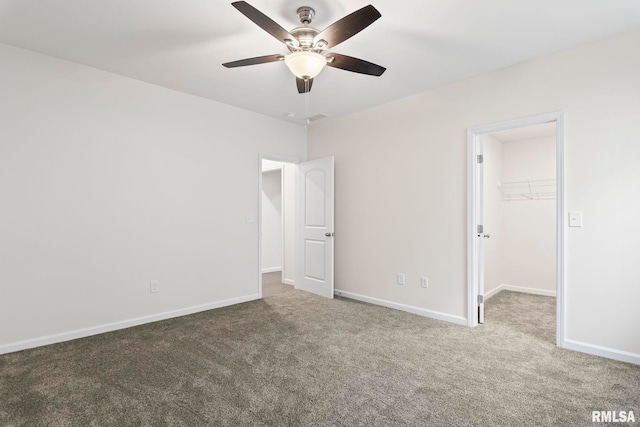 unfurnished bedroom featuring carpet flooring, a walk in closet, ceiling fan, and a closet