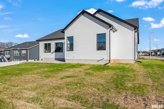 back of house with a lawn and a patio area