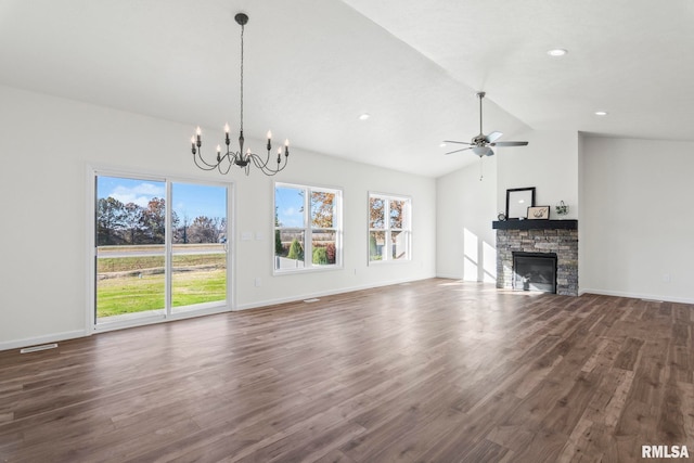 unfurnished living room featuring a stone fireplace, dark hardwood / wood-style flooring, ceiling fan with notable chandelier, and vaulted ceiling