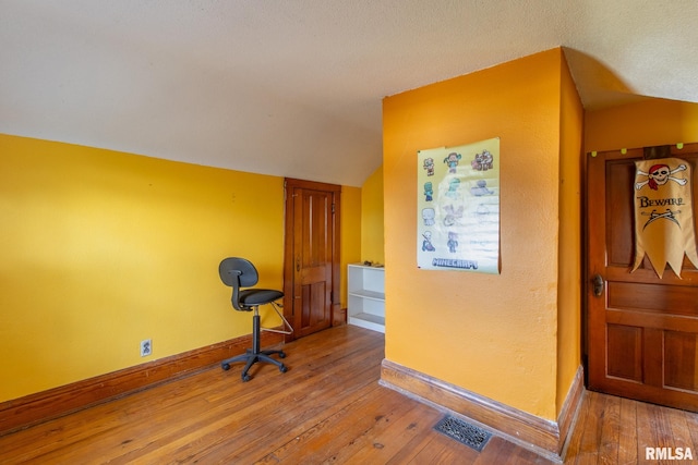 interior space with lofted ceiling and hardwood / wood-style flooring