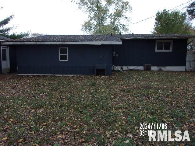 rear view of property with a yard