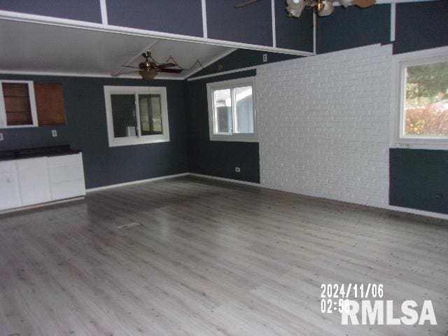 unfurnished living room featuring ceiling fan, hardwood / wood-style floors, and vaulted ceiling