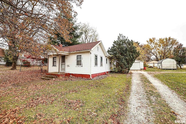 view of side of home featuring a lawn, an outdoor structure, and a garage