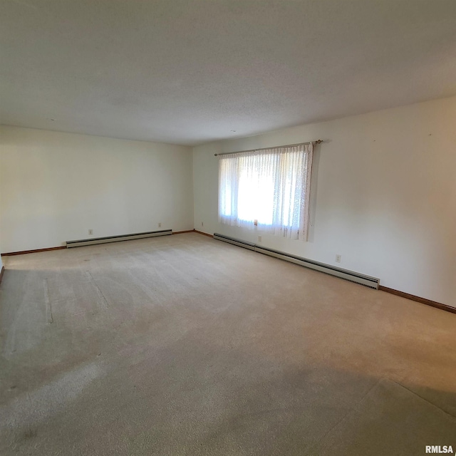 carpeted empty room featuring baseboard heating