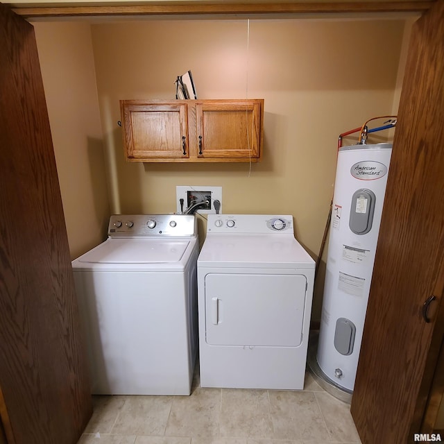 laundry area featuring cabinets, light tile patterned floors, electric water heater, and washer and clothes dryer