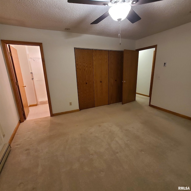 unfurnished bedroom featuring ceiling fan, a baseboard heating unit, light colored carpet, a textured ceiling, and a closet