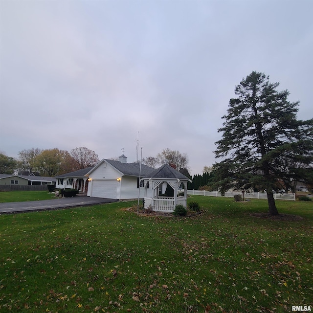 view of front of property featuring a gazebo, a front lawn, and a garage