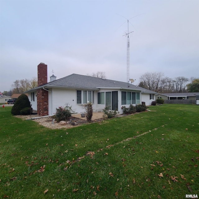 view of front of home featuring a sunroom and a front lawn