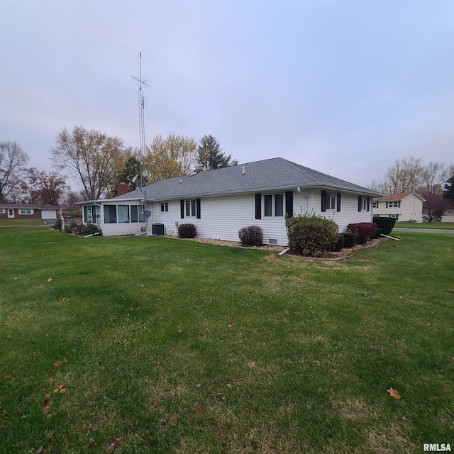 back of house with a sunroom and a lawn