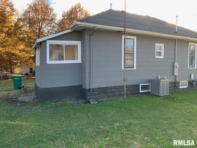 view of side of property with central air condition unit and a yard