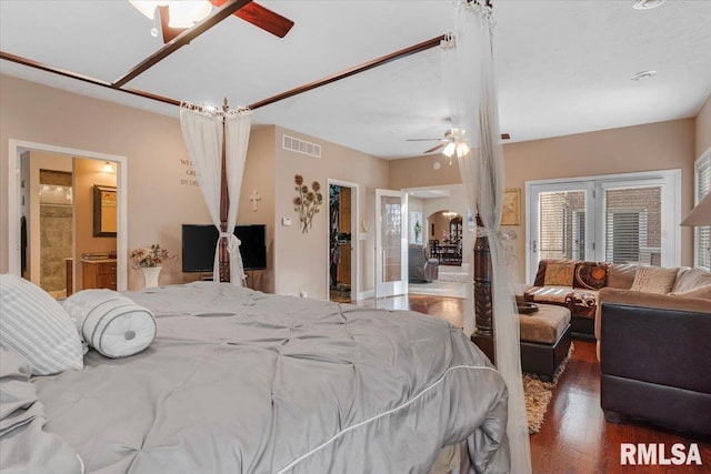 bedroom featuring hardwood / wood-style floors, a walk in closet, ensuite bathroom, and ceiling fan