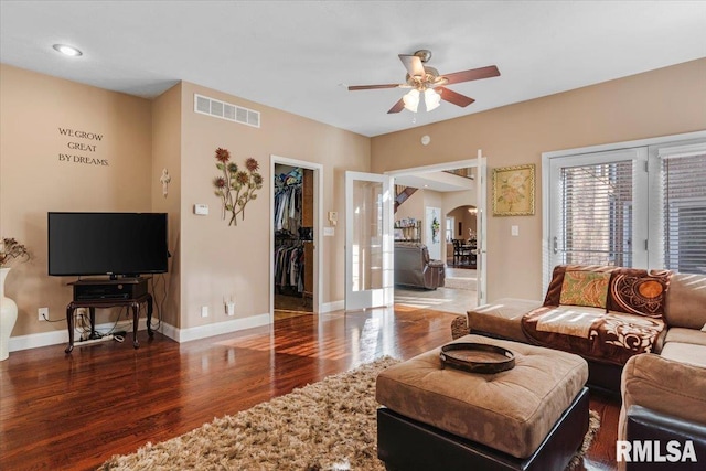 living room with dark hardwood / wood-style flooring and ceiling fan