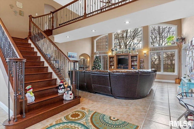 living room featuring a towering ceiling and light tile patterned floors