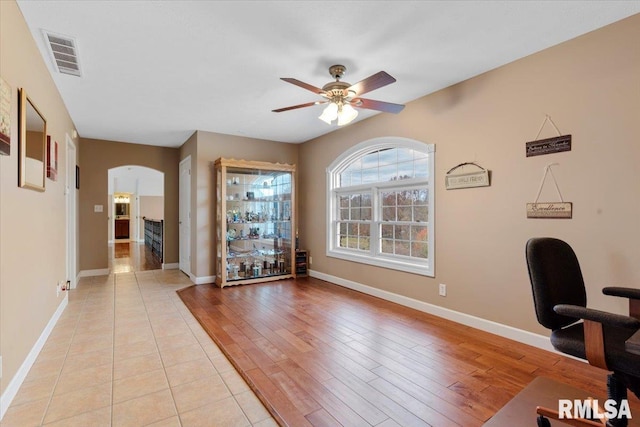 13599 Woodland Dr, Athens, IL 62613 - home office featuring a ceiling fan, arched walkways, baseboards, and light wood-style floors