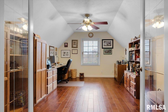 home office with a textured ceiling, vaulted ceiling, ceiling fan, and dark wood-type flooring