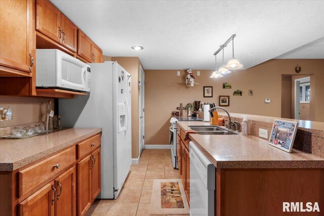 kitchen featuring white appliances, a textured ceiling, sink, light tile patterned floors, and hanging light fixtures