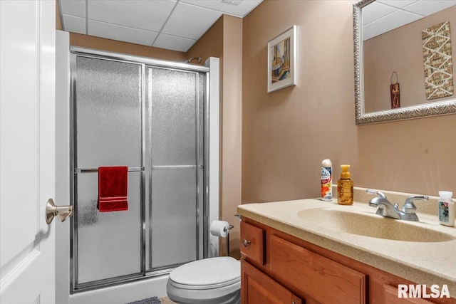 bathroom with vanity, toilet, walk in shower, and a paneled ceiling