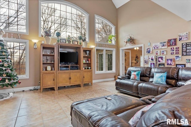 living room with light tile patterned floors and high vaulted ceiling