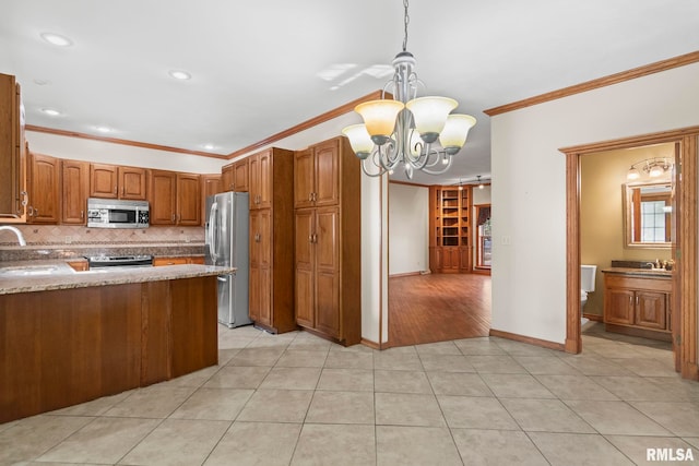 kitchen with light tile patterned floors, appliances with stainless steel finishes, ornamental molding, and hanging light fixtures