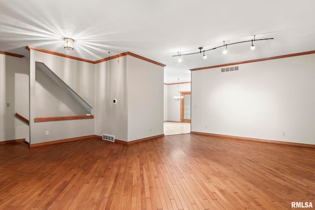 unfurnished room featuring ornamental molding, a chandelier, and wood-type flooring