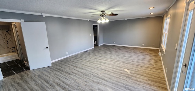 spare room featuring hardwood / wood-style floors, a textured ceiling, ceiling fan, and crown molding