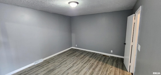 unfurnished room with a textured ceiling and hardwood / wood-style floors