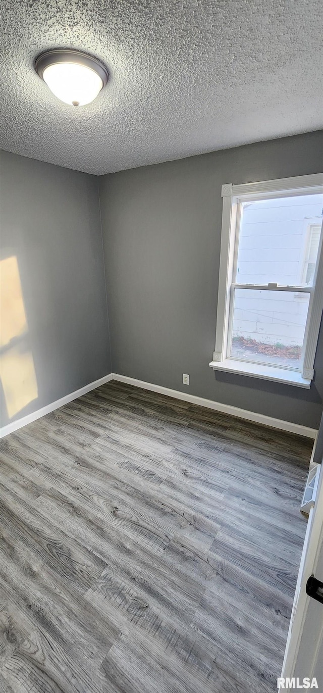 unfurnished room featuring a textured ceiling and hardwood / wood-style floors