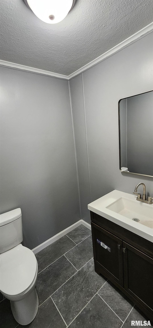 bathroom featuring toilet, vanity, and a textured ceiling