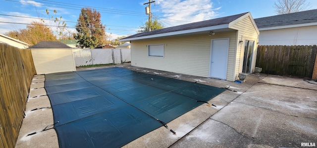 view of pool with a patio and a storage shed