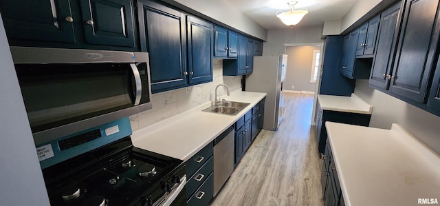 kitchen featuring light hardwood / wood-style floors, stainless steel appliances, sink, blue cabinets, and backsplash