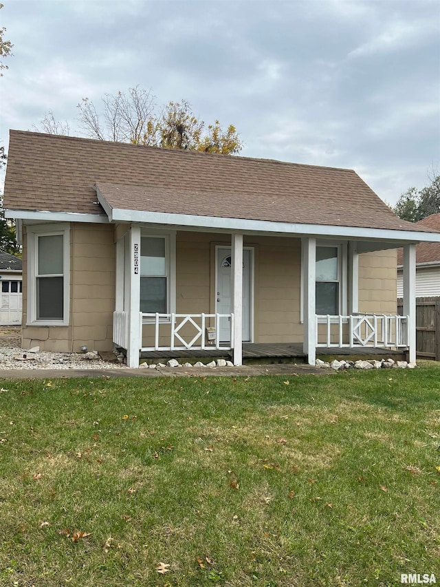 single story home featuring covered porch and a front yard