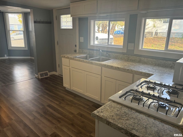 kitchen featuring white cabinetry, sink, dark wood-type flooring, and stove