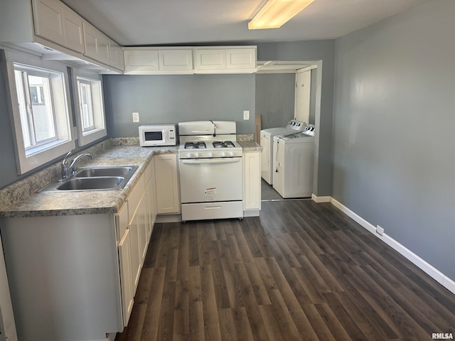 kitchen with dark hardwood / wood-style flooring, white appliances, sink, washer and dryer, and white cabinets