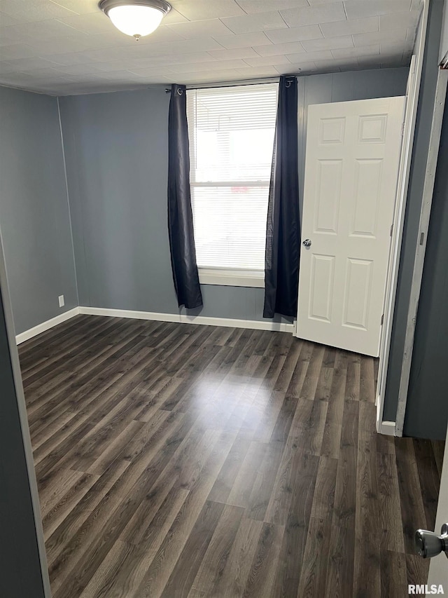 empty room with dark hardwood / wood-style flooring