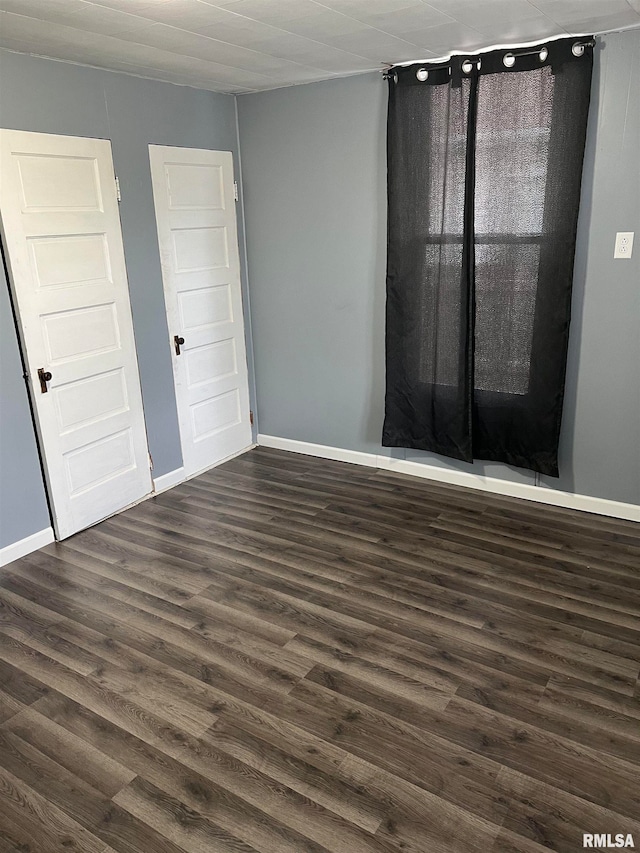 unfurnished room featuring dark wood-type flooring