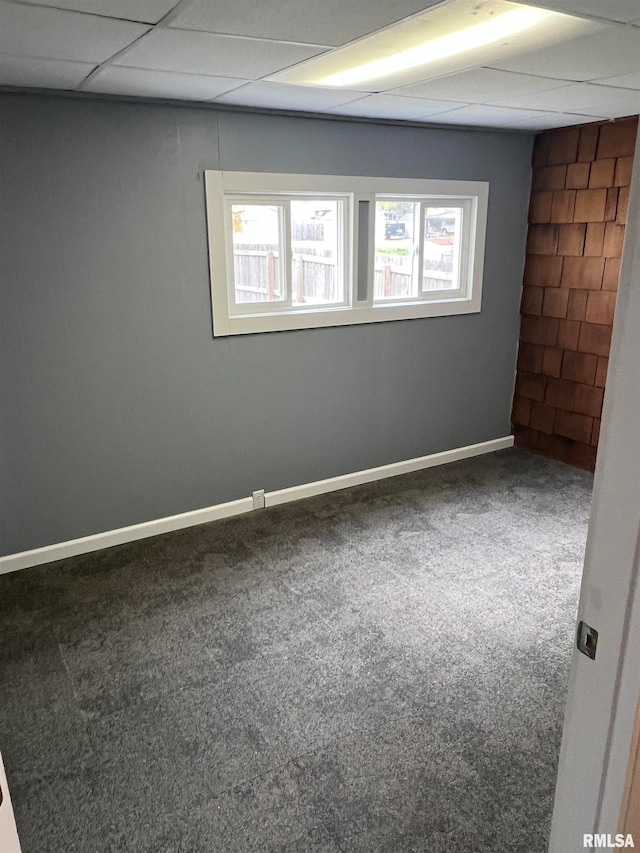 carpeted spare room with a paneled ceiling and a healthy amount of sunlight