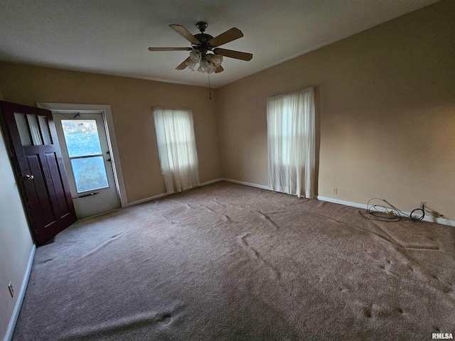 empty room with ceiling fan and light carpet